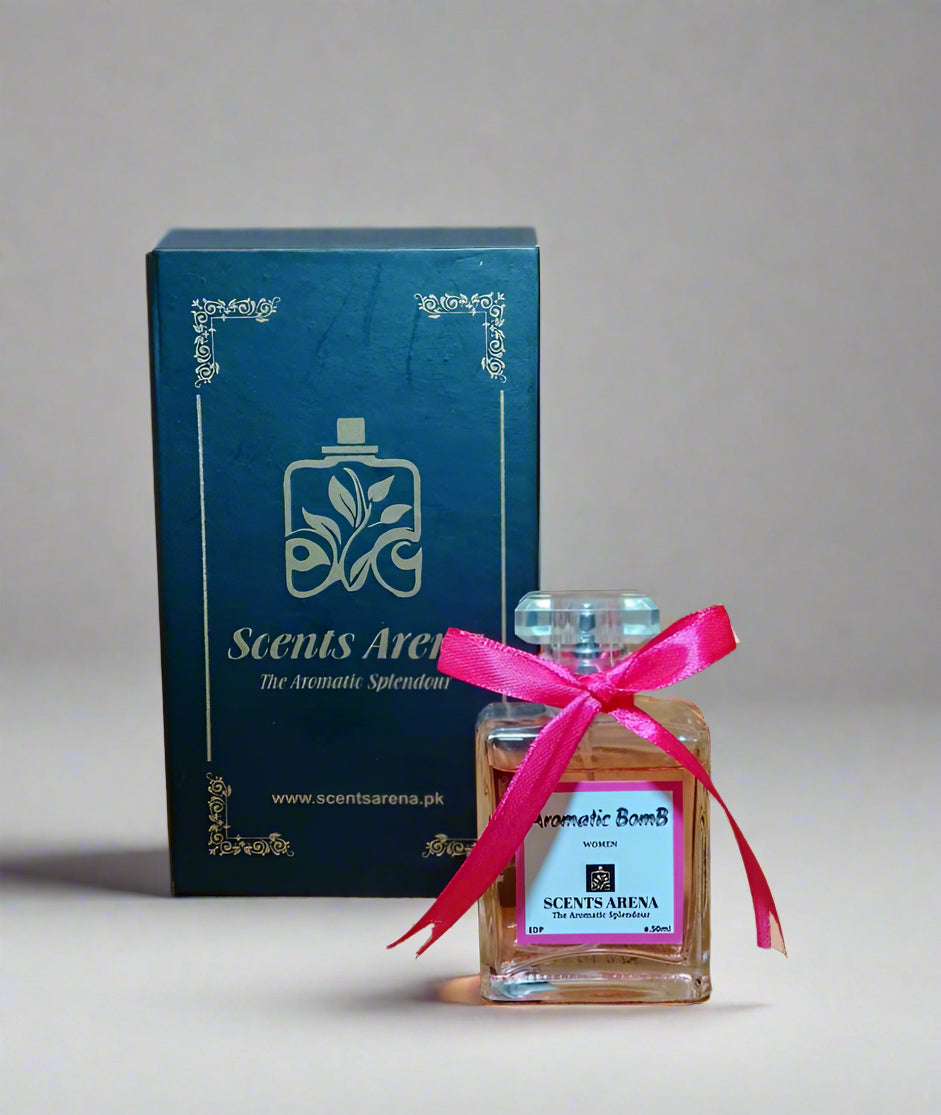 Perfume bottle with pink ribbon and Scents Arena packaging on a wooden surface