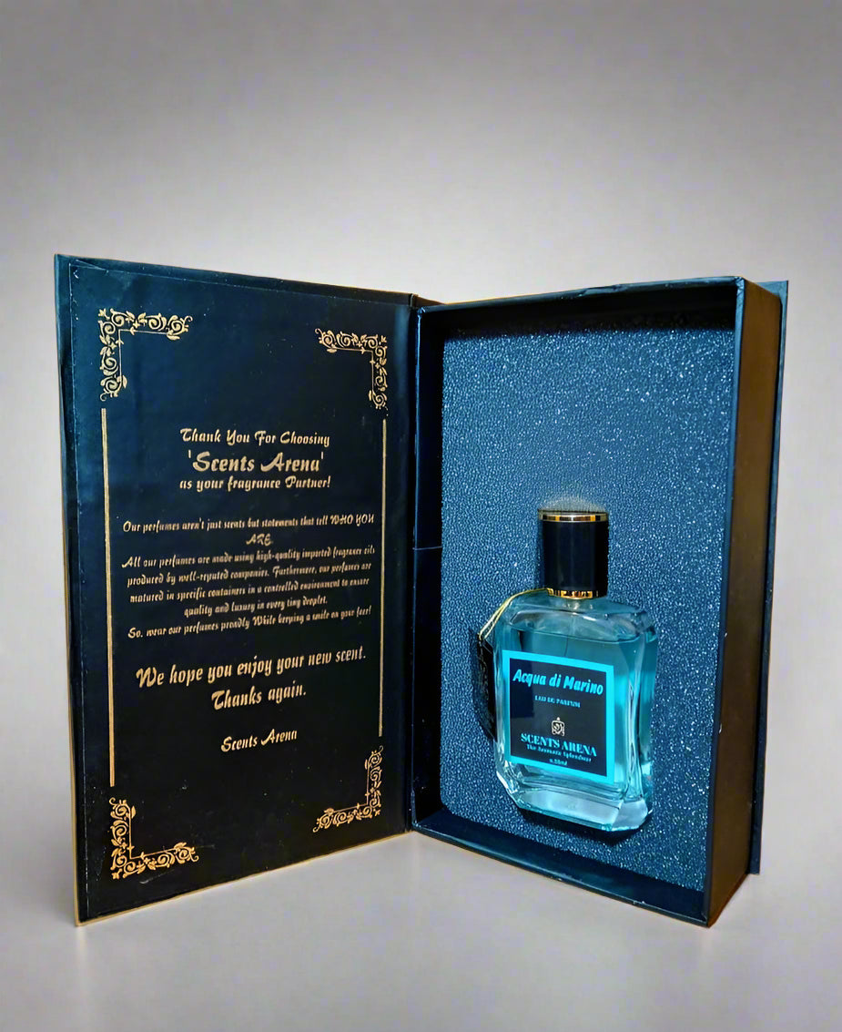 Blue perfume bottle in an open black and gold box on a wooden surface.
