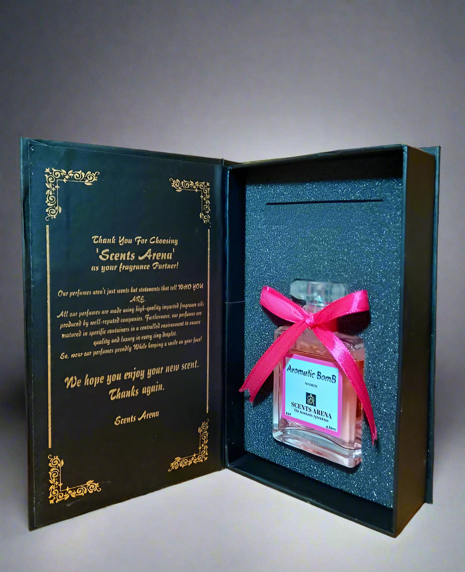 Aromatic Bomb perfume bottle by Scents Arena with a pink bow in an open black box on a wooden surface